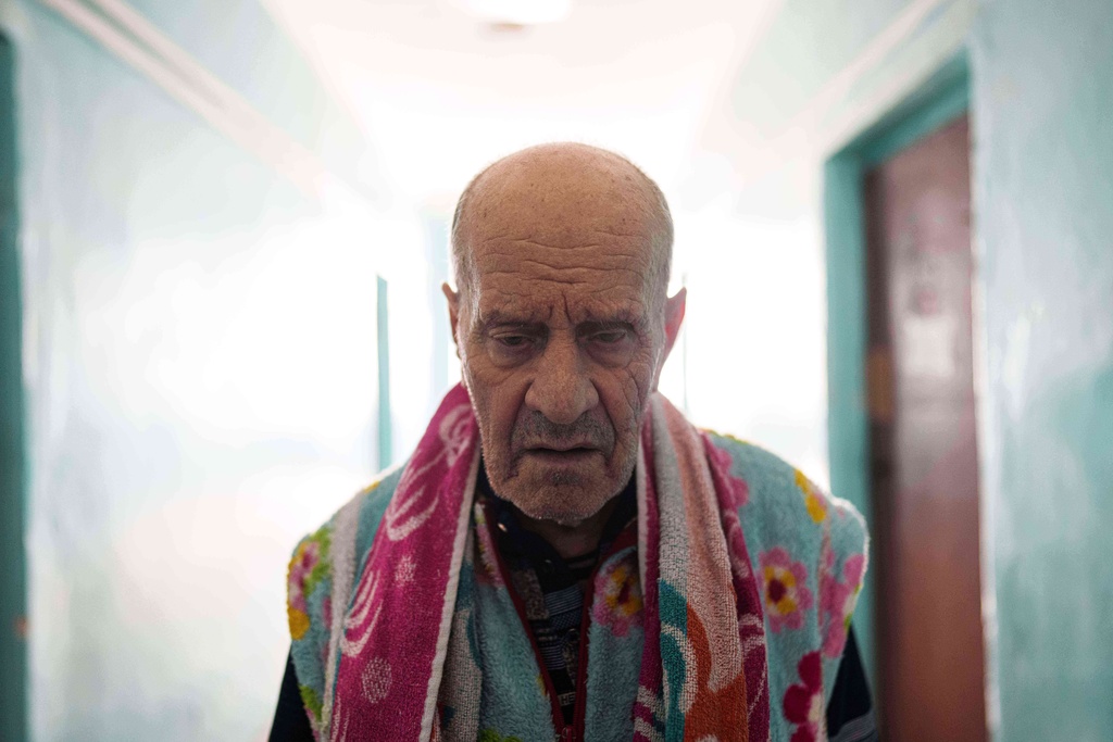 Mykola, 84, who is blind, waits for his wife in a corridor of a hostel for the displaced in Dnipro, Ukraine, Wednesday, Oct. 8, 2025. (AP Photo/Evgeniy Maloletka)