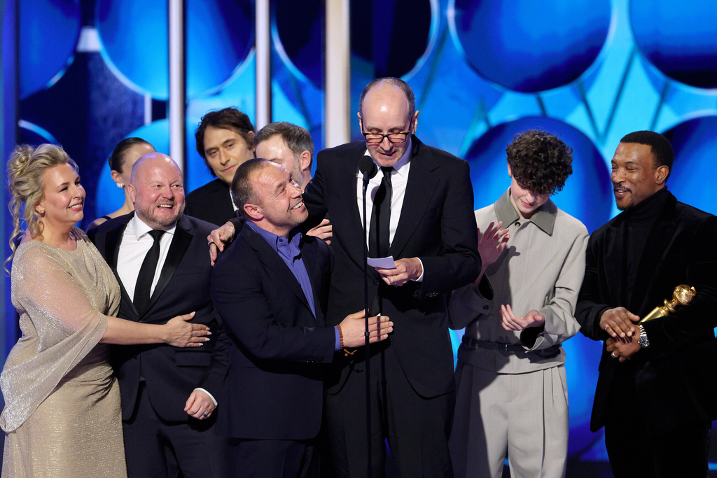 This image released by CBS Broadcasting shows Jack Thorne, center, flanked by Stephen Graham, center left, and Owen Cooper, as they appear with other cast members of "Adolescence" after winning the award for best limited series during the 83rd Golden Globes on Sunday, Jan. 11, 2026, at the Beverly Hilton in Beverly Hills, Calif. (Kevork Djansezian/CBS Broadcasting via AP)