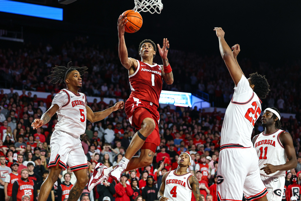 Arkansas Razorbacks guard Meleek Thomas (1) shoots against Georgia Bulldogs guard Jeremiah Wilkinson (5) and forward Justin Abson, right, during the first half of an NCAA college basketball game, Saturday, Jan. 17, 2026, in Athens, Ga. (AP Photo/Colin Hubbard)