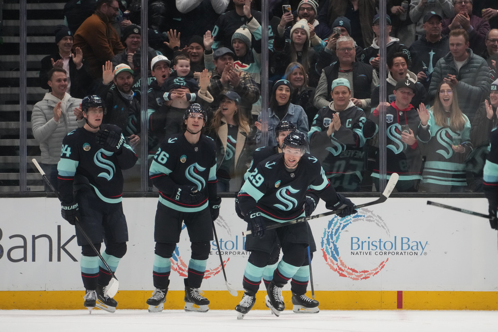 Seattle Kraken defenseman Vince Dunn (29) skates back to the bench after celebrating his goal against the New York Islanders with right wing Kaapo Kakko (84) and center Ryan Winterton (26) during the second period of an NHL hockey game Wednesday, Jan. 21, 2026, in Seattle. (AP Photo/Lindsey Wasson)