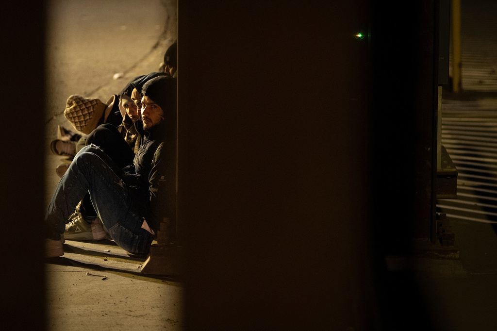 FILE - A group of migrants wait to be processed between two border walls separating Mexico and the United States after crossing illegally before dawn, Jan. 21, 2025, in San Diego. (AP Photo/Gregory Bull, File)