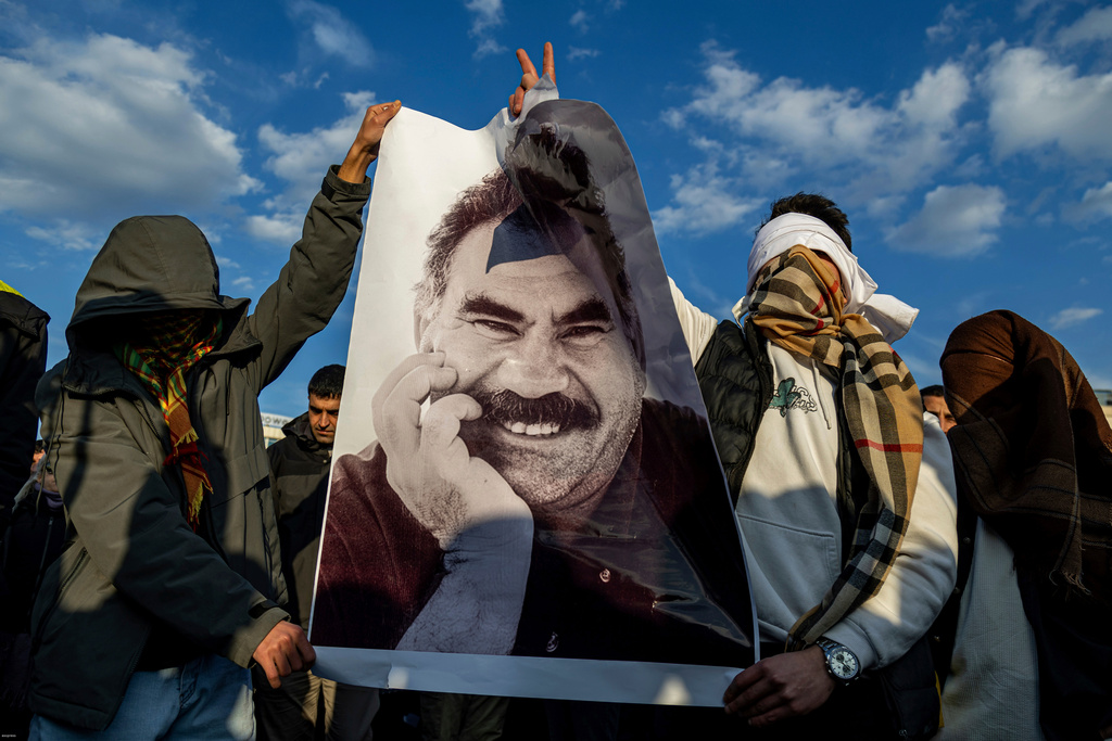 FILE - Youngsters hold a photograph of Abdullah Ocalan, the jailed leader of the militant Kurdish group, or PKK, in Diyarbakir, Turkey, Feb. 27, 2025. (AP Photo/Metin Yoksu, File)