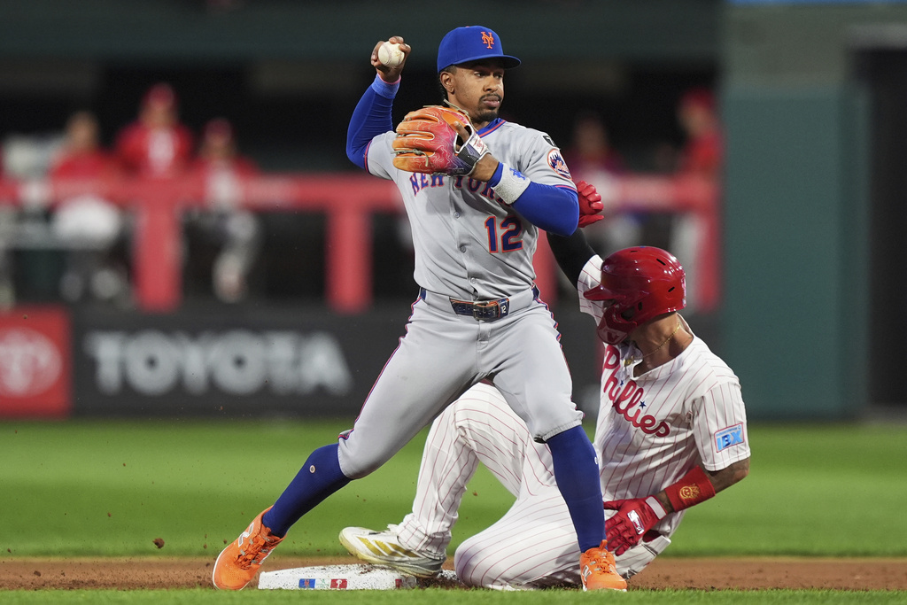New York Mets shortstop Francisco Lindor, left, forces out Philadelphia Phillies' Nick Castellanos at second on a fielder's choice hit into by Philadelphia Phillies' Bryson Stott during the second inning of a baseball game Monday, Sept. 8, 2025, in Philadelphia. (AP Photo/Matt Slocum)