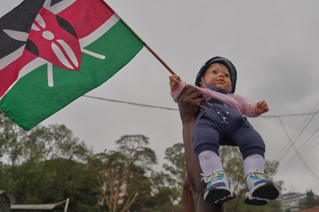 Kenyan nurses hold a Kenyan flag and a doll during a protest over low pay in Nairobi, Kenya Tuesday, Sept. 8, 2026. (AP Photo/Brian Inganga)