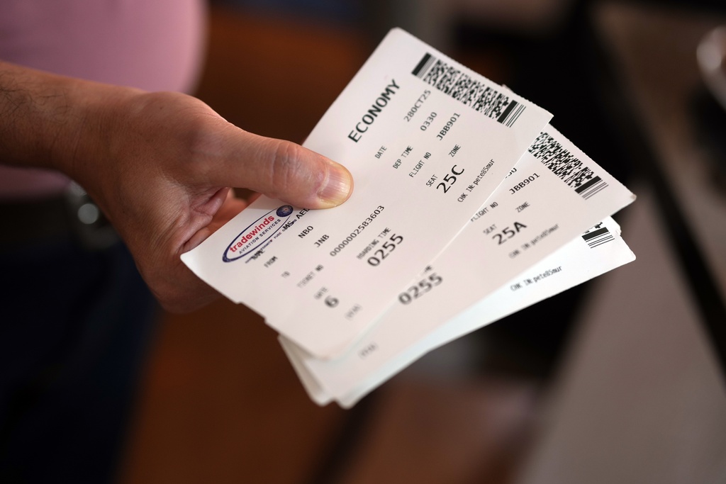 A Palestinian man who traveled to South Africa via a charter flight organized by an Israeli group whose founder supported U.S. President Donald Trump's proposal to resettle Palestinians from Gaza, shows his boarding passes in his temporary flat in Johannesburg, South Africa, Wednesday, Feb. 4, 2026. (AP Photo/Jerome Delay)