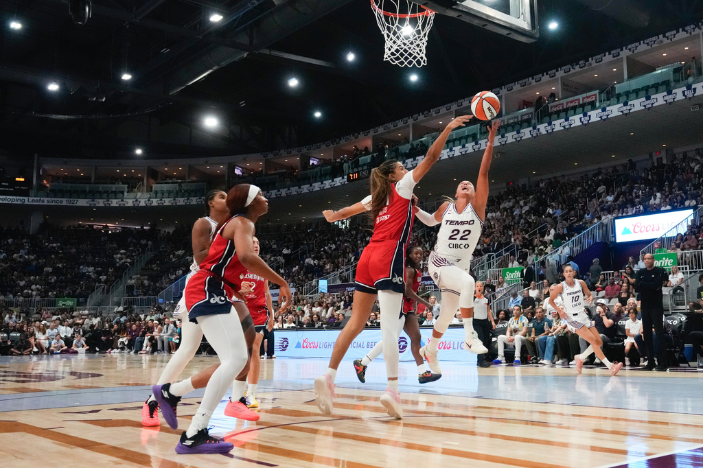 Toronto Tempo's Julie Altmand (22) shoots on Washington Mystics' Lauren Betts, center, during the first half of a WNBA basketball game in Toronto, Tuesday, July 14, 2026. (Chris Young/The Canadian Press via AP)