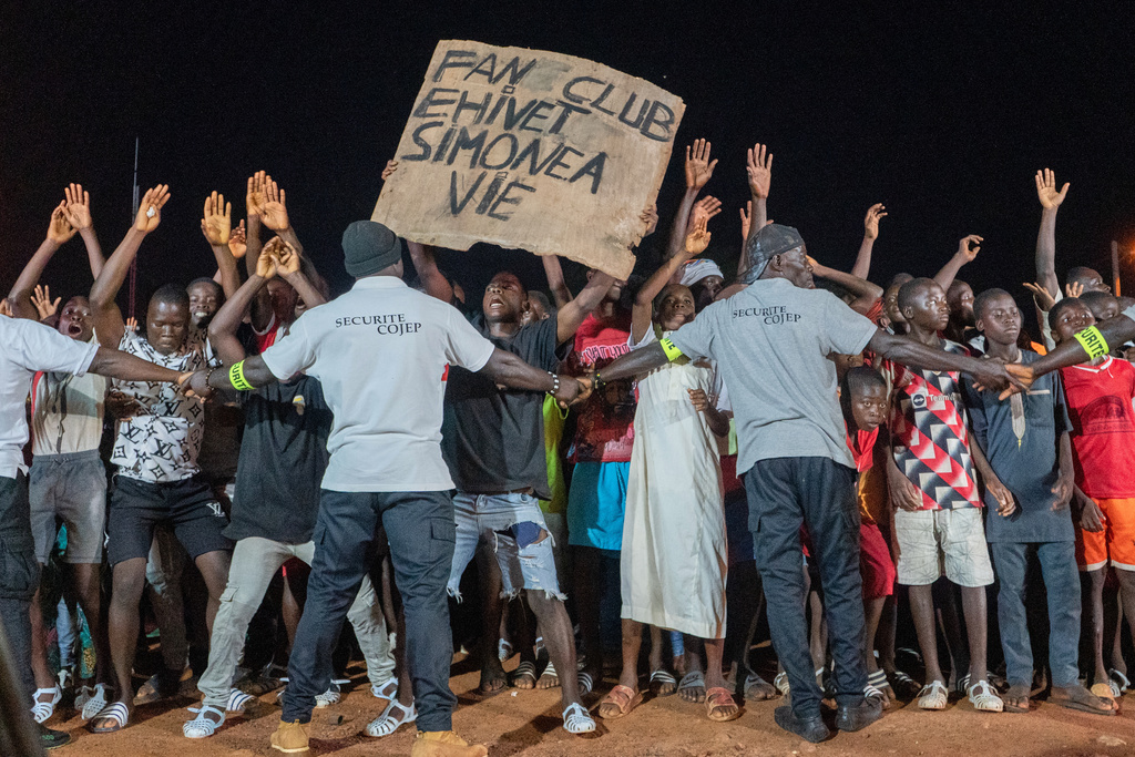 Supporters of Simone Ehivet Gbagbo cheer and hold a sign during a rally in Guiberoua, Ivory Coast, Tuesday, Oct 14, 2025. (AP Photo/ Marine Jeannin)