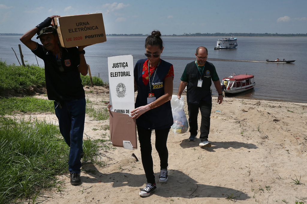 Electoral workers unload electronic voting machines to be taken to a polling station a day ahead of the country's general elections in the rural riverside community of Costa do Jatuarana, Amazonas state, Brazil, Saturday, Oct. 3, 2026. (AP Photo/Edmar Barros)