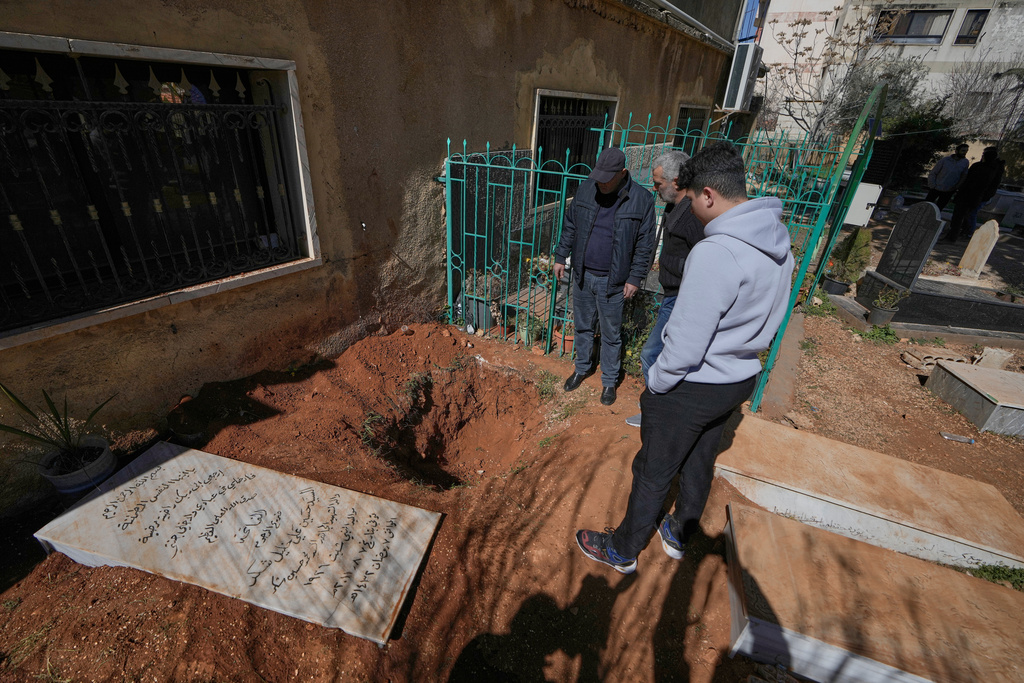 People look at the grave that was dug by Israeli forces landed late Friday, searching for Israeli co-pilot Ron Arad who was captured and then went missing after his fighter jet crashed over south Lebanon in 1986, in Nabi Chit village, eastern Lebanon, Sunday, March 8, 2026. (AP Photo/Bilal Hussein)