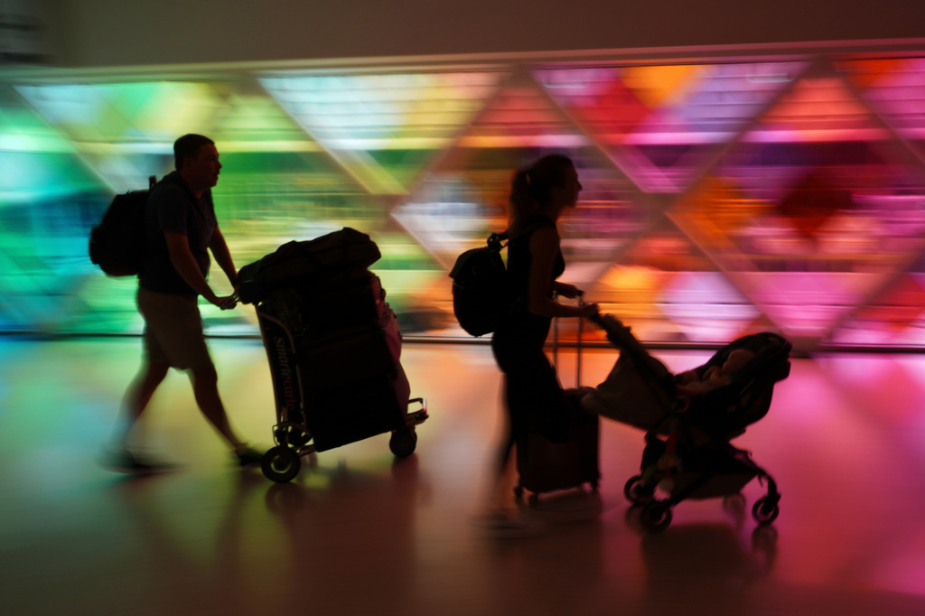 FILE - Travelers arrive at Miami International Airport at the start of the Labor Day weekend in Miami, Aug. 29, 2025. (AP Photo/Rebecca Blackwell, File)