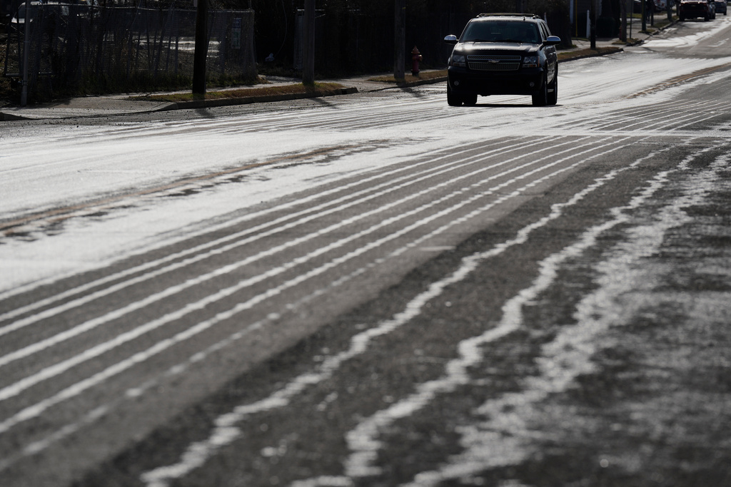 A motorist travels on a road that has been treated with salt brine Thursday, Jan. 22, 2026, in Nashville, Tenn. ahead of a winter storm expected to hit the state over the weekend. (AP Photo/George Walker IV)