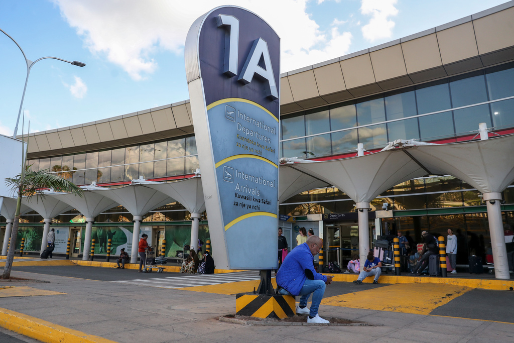 FILE - People wait outside the Jomo Kenyatta International Airport in Nairobi, Kenya, Nov. 7, 2022. (AP Photo/Brian Inganga, file)