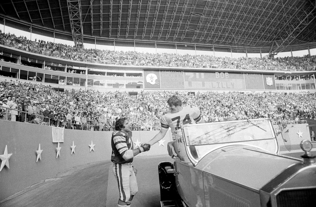 FILE - Philadelphia Eagles guard John Niland (74), right, shakes hands with retired Dallas Cowboys tackle Bob Lilly (74) during half-time ceremonies honoring Lilly at Texas Stadium in Irving, Nov. 23, 1975. Niland and Lilly were teammates the previous year. (AP Photo/Ferd Kaufman, File)