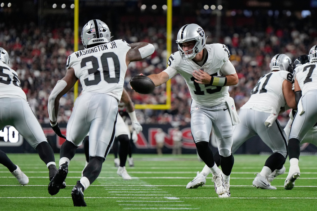 Las Vegas Raiders quarterback Fernando Mendoza (15) hands off to Las Vegas Raiders running back Mike Washington Jr. (30) during the first half of an NFL preseason football game against the Houston Texans, Thursday, Aug. 20, 2026, in Houston. (AP Photo/Ashley Landis)