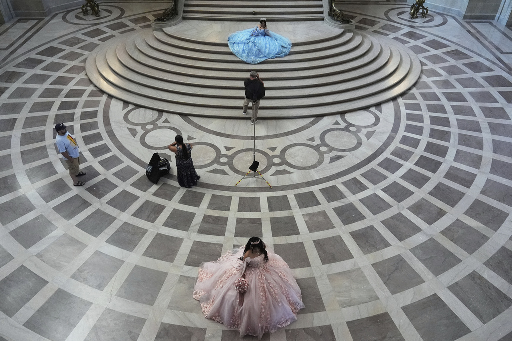 Abbie Gonzalez, top, poses for photographer Miguel Plascencia as she has her quinceañera portrait session taken at City Hall in San Francisco, Monday, Aug. 25, 2025. (AP Photo/Jeff Chiu)