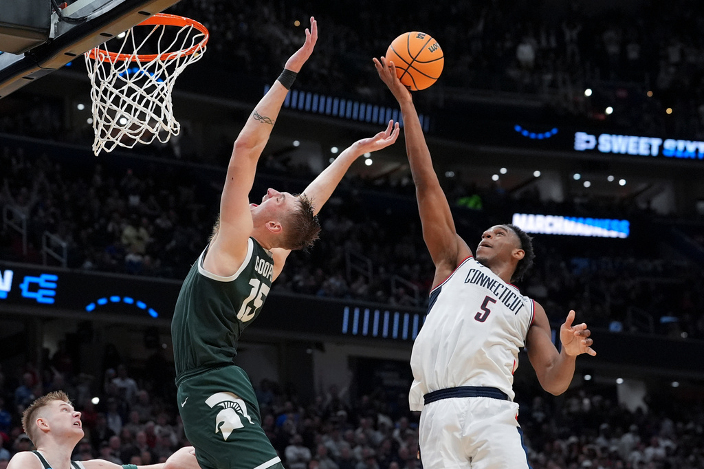 UConn forward Tarris Reed Jr. (5) rebounds over Michigan State center Carson Cooper (15) during the second half in the Sweet 16 of the NCAA college basketball tournament, Saturday, March 28, 2026, in Washington. (AP Photo/Stephanie Scarbrough)
