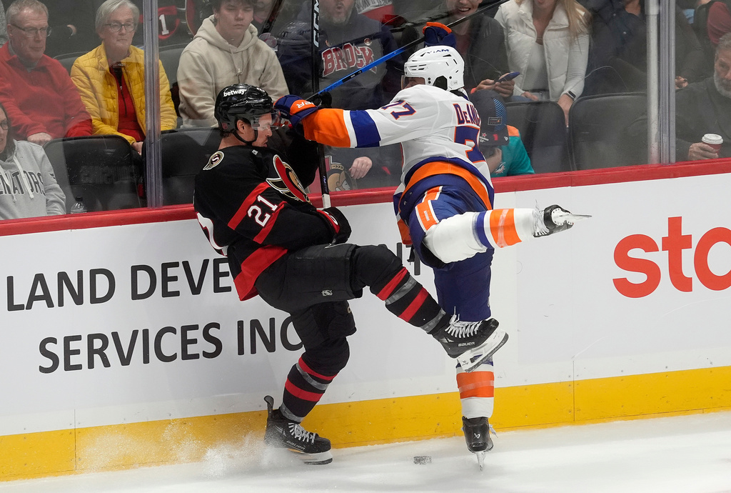 New York Islanders defenceman Tony Deangelo (77) collides with Ottawa Senators centre Nick Cousins (21) during second period NHL action in Ottawa, Saturday, Oct. 18, 2025. (Adrian Wyld/The Canadian Press via AP)