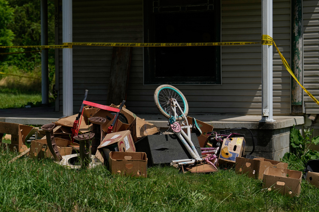 Police tape and debris are seen at a home where authorities say they removed 16 children and arrested four adults in Hamden, Ohio, Wednesday, July 1, 2026. (AP Photo/Carolyn Kaster)