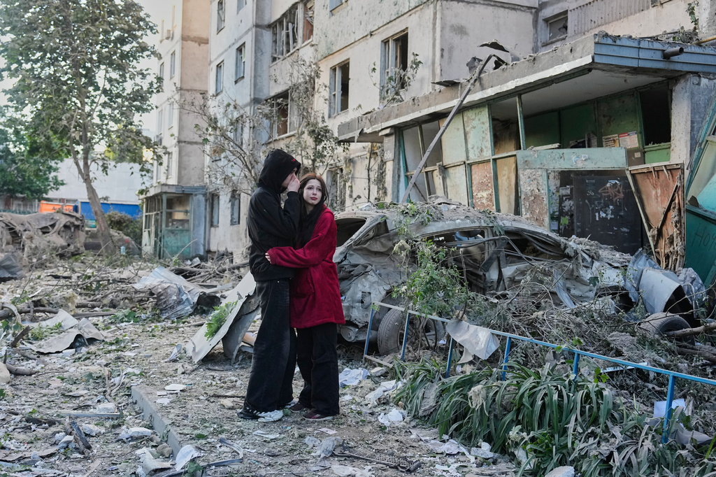 People react as they look at the site of a Russian missile strike that hit a residential building in Kyiv, Ukraine, Tuesday, June 2, 2026. (AP Photo/Efrem Lukatsky)