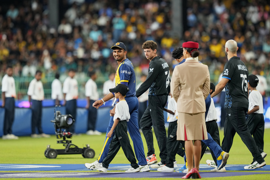 Sri Lanka's captain Dasun Shanaka, left, and New Zealand's captain Mitchel Santner arrive for their national anthem before the start of their T20 World Cup cricket match between Sri Lanka and New Zealand in Colombo, Sri Lanka, Wednesday, Feb. 25, 2026. (AP Photo/Eranga Jayawardena)