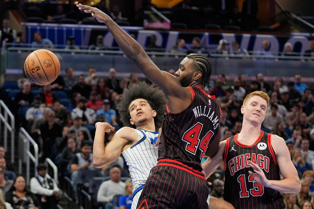 Orlando Magic guard Anthony Black, left, loses control of the ball as he collides with Chicago Bulls forward Patrick Williams (44) and guard Kevin Huerter (13) during the first half of an NBA basketball game, Monday, Dec. 1, 2025, in Orlando, Fla. (AP Photo/John Raoux)