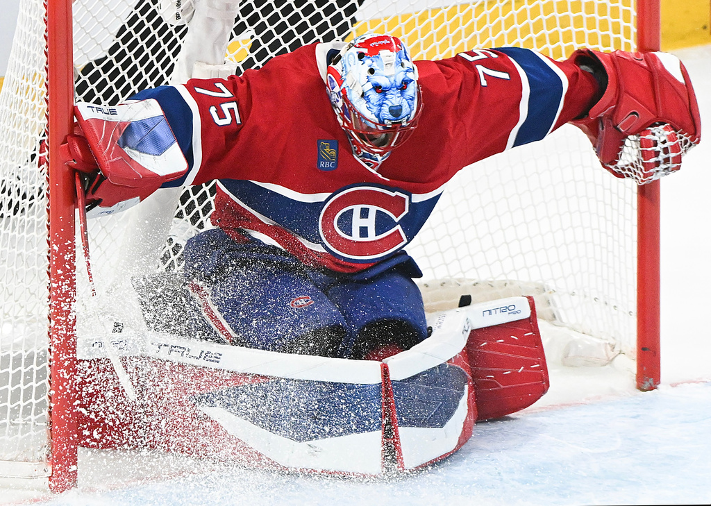 Montreal Canadiens goaltender Jakub Dobes smothers the puck just outside the net following a shot by Carolina Hurricanes' Sebastian Aho during the third period of Game 3 of the Eastern Conference finals NHL hockey Stanley Cup playoff series in Montreal, Monday, May 25, 2026. (Graham Hughes/The Canadian Press via AP)