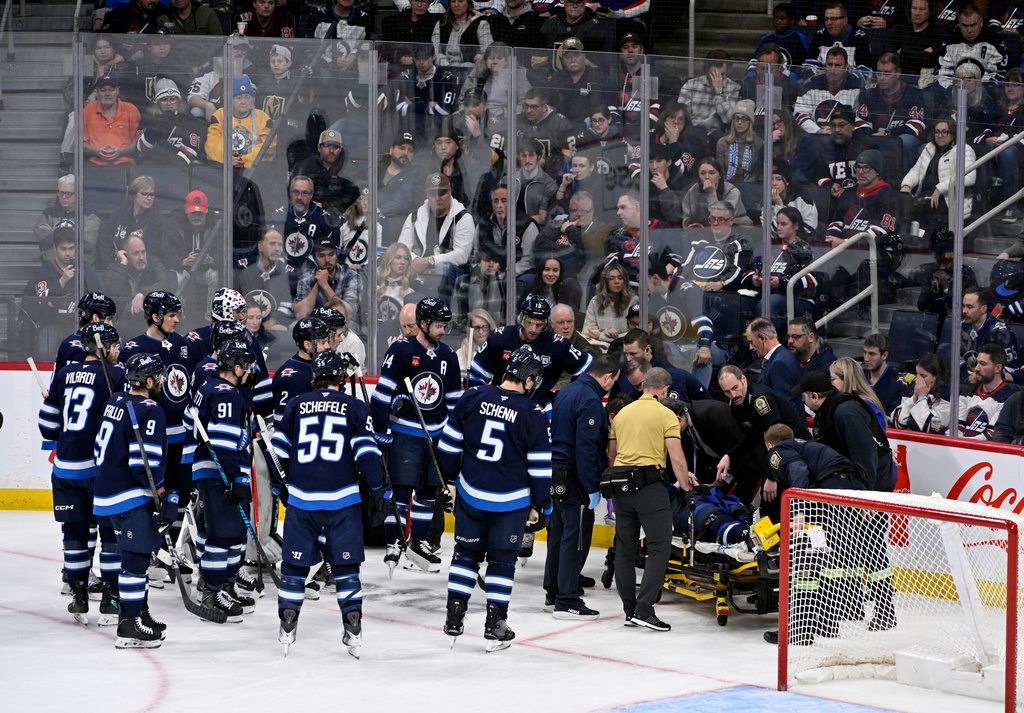 Winnipeg Jets' Haydn Fleury is helped off the ice after being injured against the Vegas Golden Knights during the first period of their NHL hockey game in Winnipeg, Tuesday Jan. 6, 2026. (Fred Greenslade/The Canadian Press via AP)