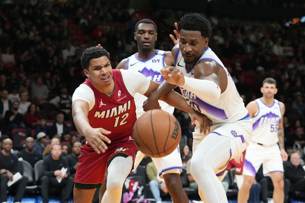 Miami Heat guard Dru Smith (12) and Utah Jazz forward Jaren Jackson Jr. (20) go after a loose ball during the first half of an NBA basketball game Monday, Feb. 9, 2026, in Miami. (AP Photo/Marta Lavandier)