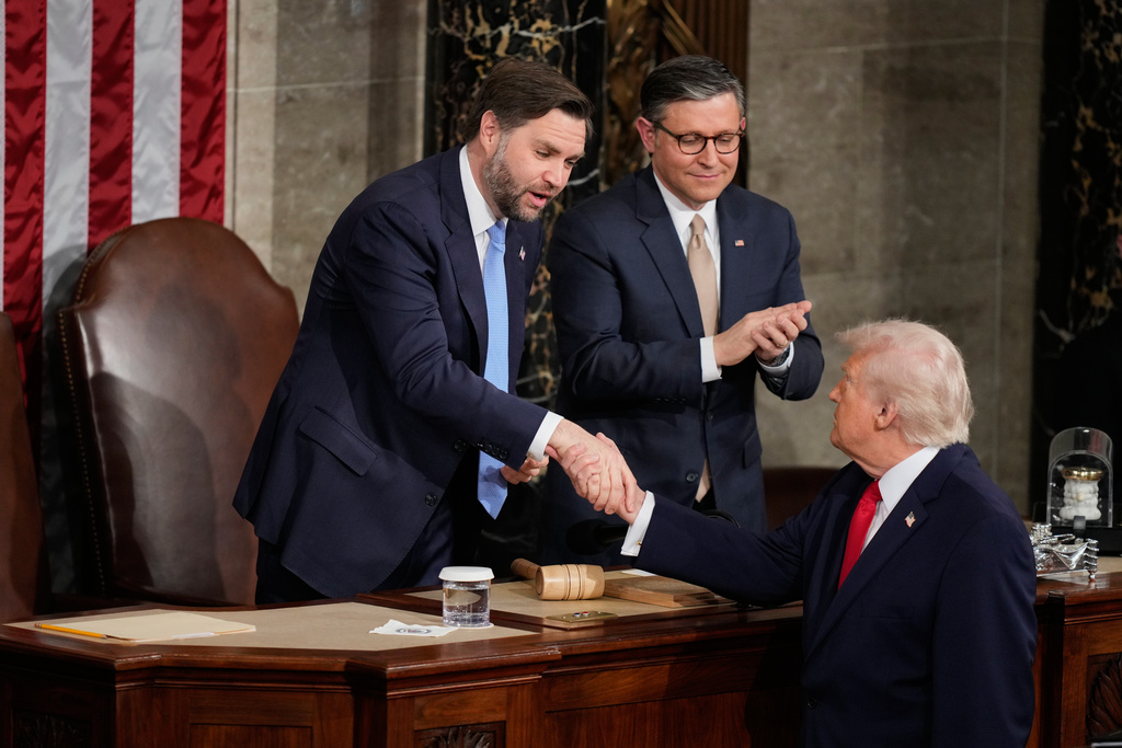 Vice President JD Vance shakes hands with President Donald Trump following his State of the Union address to a joint session of Congress in the House chamber at the U.S. Capitol in Washington, Tuesday, Feb. 24, 2026. House Speaker Mike Johnson is standing to the right of Vice President JD Vance. (AP Photo/Alex Brandon)
