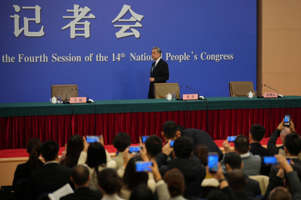 Journalists film Chinese Foreign Minister Wang Yi arrives for a press conference on the sideline of the National People's Congress (NPC) at the media center, in Beijing, Sunday, March 8, 2026. (AP Photo/Andy Wong)
