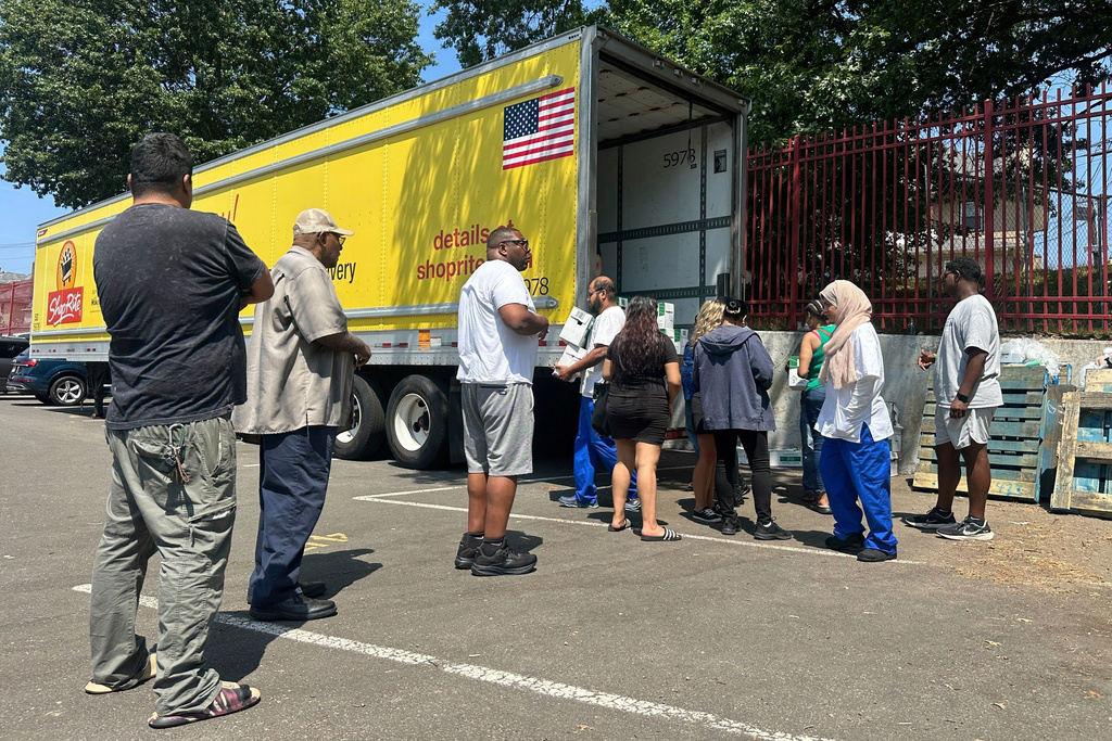 People, who were affected by a water main break that that led to reduced service to nearly 200,000 homes and businesses, pick up cases of bottled water at John F. Kennedy High School in Paterson, N.J., on Aug. 11, 2025. (AP Photo/Ted Shaffrey)