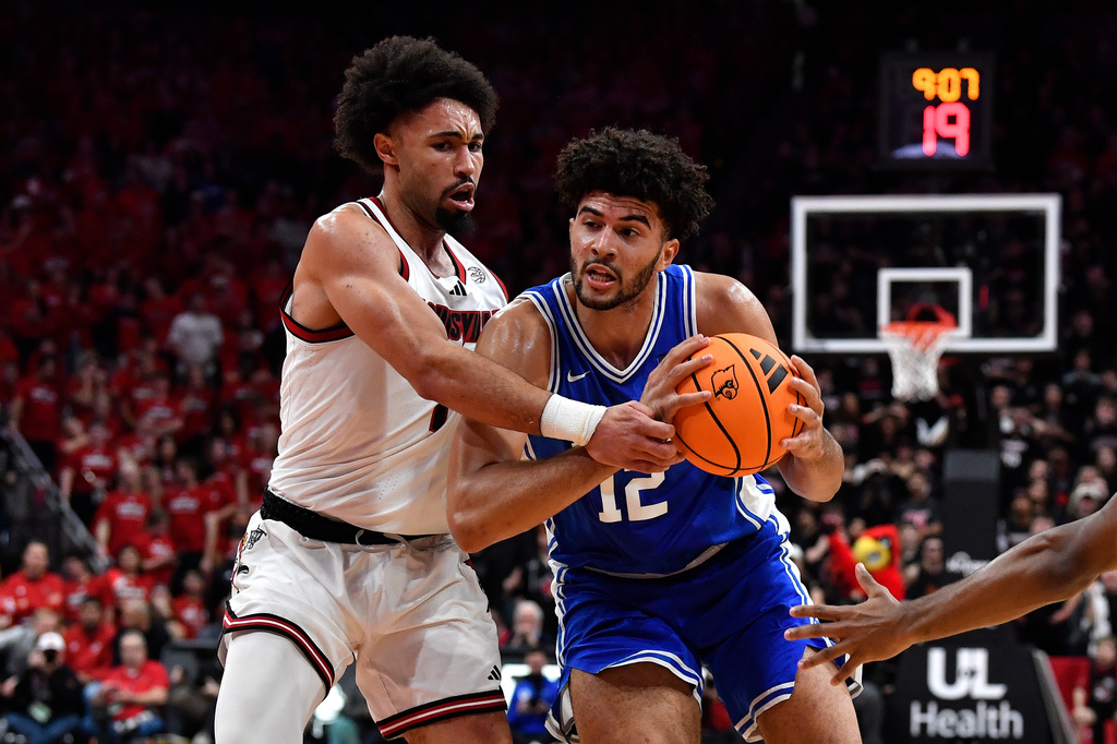 Duke forward Cameron Boozer (12) attempts to get past Louisville guard J'vonne Hadley (1) during the first half of an NCAA college basketball game in Louisville, Ky., Tuesday, Jan. 6, 2026. (AP Photo/Timothy D. Easley)