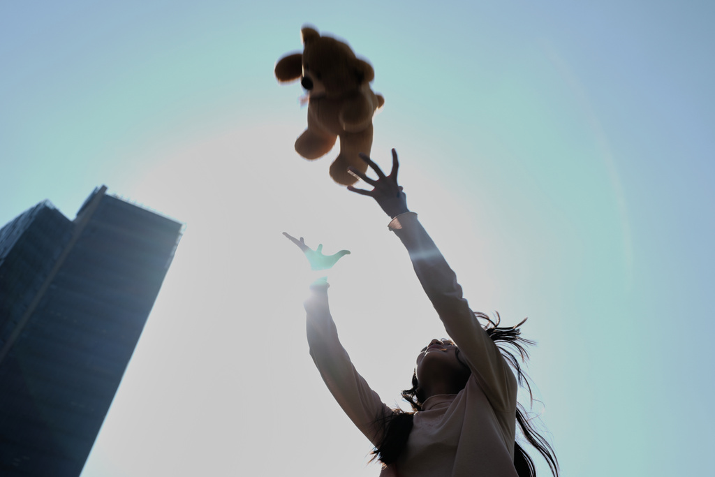 FILE - A child playfully tosses into the air a teddy bear she was gifted at an event celebrating Three Kings Day at the base of the Angel of Independence monument, in Mexico City, Jan. 5, 2026. (AP Photo/Marco Ugarte, File)