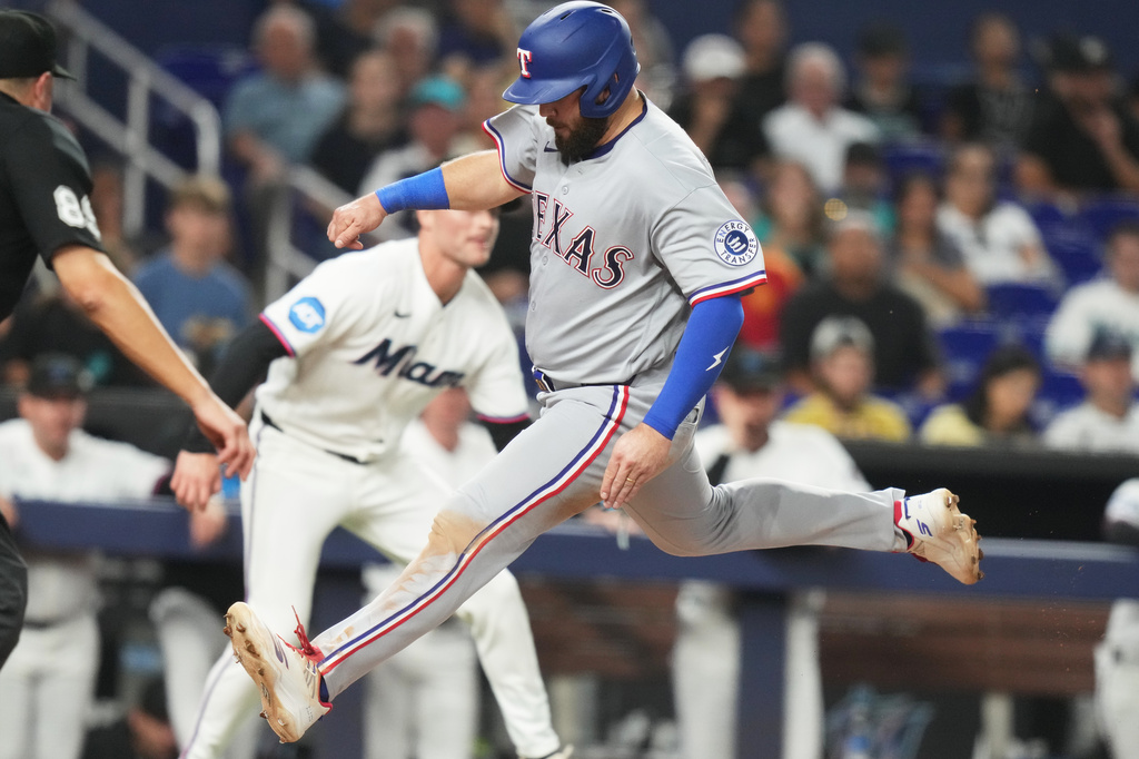 Texas Rangers' Jake Burger scores on a sacrifice fly hit by Elias Díaz during the eighth inning of a baseball game against the Miami Marlins, Monday, June 22, 2026, in Miami. (AP Photo/Lynne Sladky)