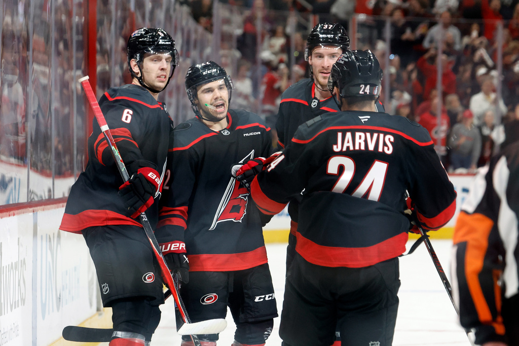 Carolina Hurricanes' Logan Stankoven (22) celebrates after his second goal with teammates Mike Reilly (6), Andrei Svechnikov, back right, and Seth Jarvis (24) during the second period of Game 1 of an NHL hockey Stanley Cup second-round playoff series against the Philadelphia Flyers in Raleigh, N.C., Saturday, May 2, 2026. (AP Photo/Karl DeBlaker)