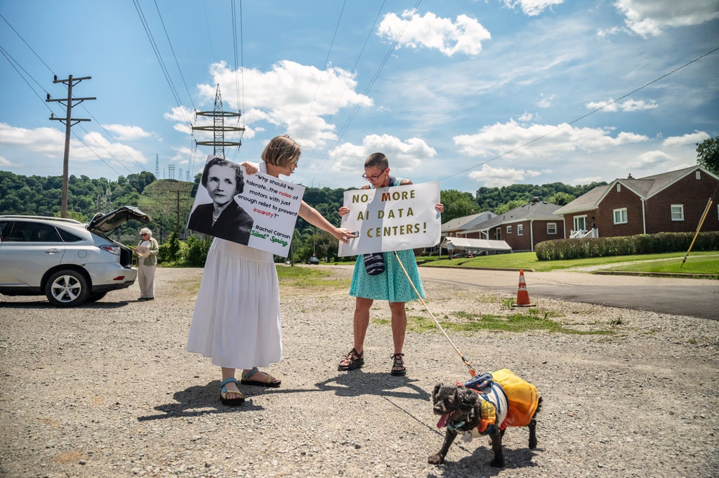Charolette Baierl, the Ohio River Valley regional organizer for Climate Reality Project, left, and Sally Simpson, a Ford City organizer, protest a planned data center near the Rachel Carson Riverfront Park in Cheswick, Pa., on June 13, 2026. (Stephanie Strasburg/Pittsburgh's Public Source via AP)
