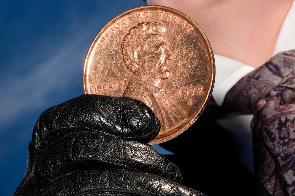 FILE - A person holds a giant penny at a mock funeral for the coin, Dec. 20, 2025, in front of the Lincoln Memorial in Washington. (AP Photo/Julia Demaree Nikhinson, File)