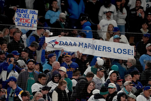 Toronto Blue Jays fans hold signs during the eighth inning in Game 3 of baseball's American League Championship Series against the Seattle Mariners, Wednesday, Oct. 15, 2025, in Seattle. (AP Photo/Lindsey Wasson) Toronto Blue Jays fans hold signs during the eighth inning in Game 3 of baseball's American League Championship Series against the Seattle Mariners, Wednesday, Oct. 15, 2025, in Seattle. (AP Photo/Lindsey Wasson)