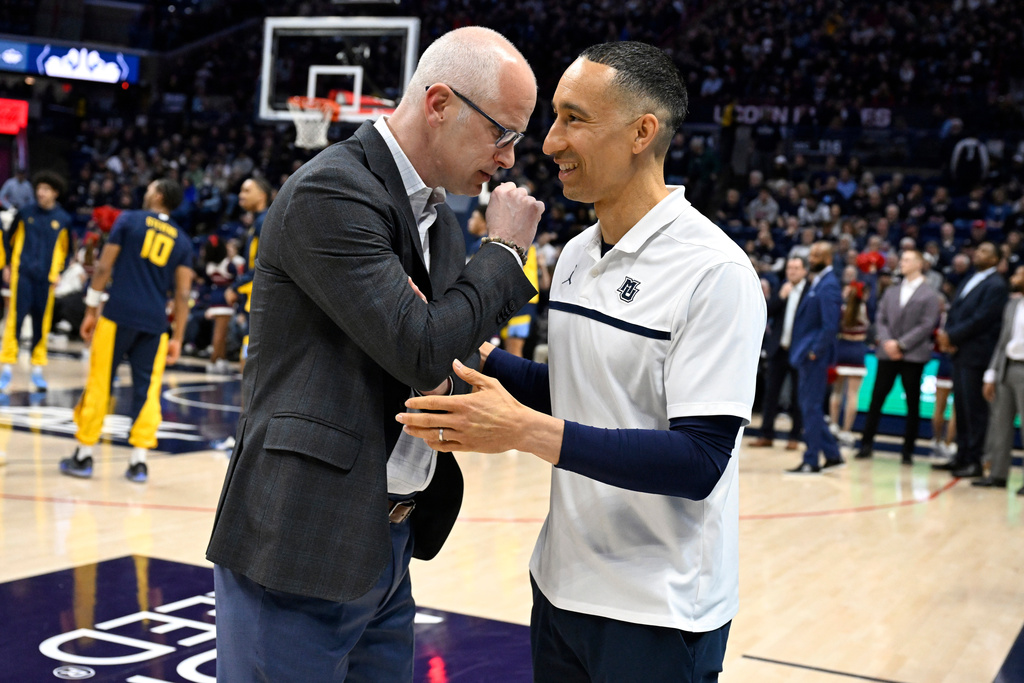 UConn head coach Dan Hurley, left, talks with Marquette head coach Shaka Smart, right, before an NCAA college basketball game, Sunday, Jan. 4, 2026, in Storrs, Conn. (AP Photo/Jessica Hill)