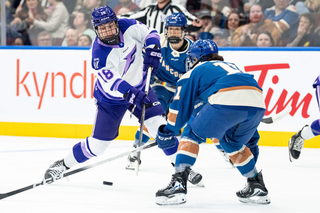 Minnesota Frost's Elizabeth Giguere (18) shoots as Vancouver Goldeneyes' Sydney Bard (11) defends during the second period of a PWHL hockey game in Vancouver, British Columbia, Saturday, April 25, 2026. (Ethan Cairns/The Canadian Press via AP)