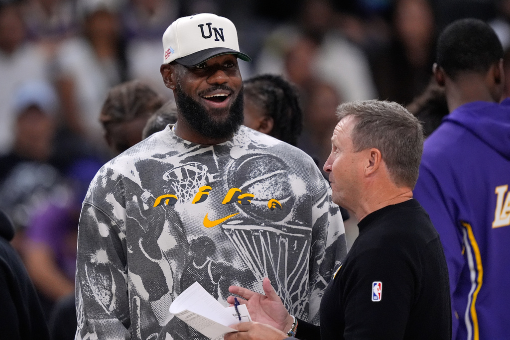 Los Angeles Lakers forward LeBron James, left, talks with assistant coach Scott Brooks during the second half of an NBA preseason basketball game against the Phoenix Suns, Friday, Oct. 3, 2025, in Palm Desert, Calif. (AP Photo/Mark J. Terrill)
