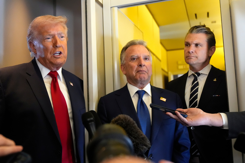 President Donald Trump speaks to reporters as White House Special Envoy to the Middle East Steve Witkoff, center, and Defense Secretary Pete Hegseth listen while traveling aboard Air Force One en route from Dover Air Force Base, Del., to Miami, Saturday, March 7, 2026. (AP Photo/Mark Schiefelbein)