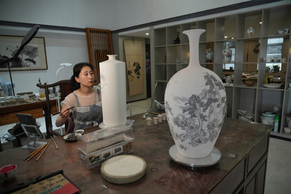 Chinese porcelain artist Chen Qing paints a vase in Jingdezhen, in eastern China's Jiangxi province, Tuesday, Sept. 1, 2026. (AP Photo/Achmad Ibrahim)