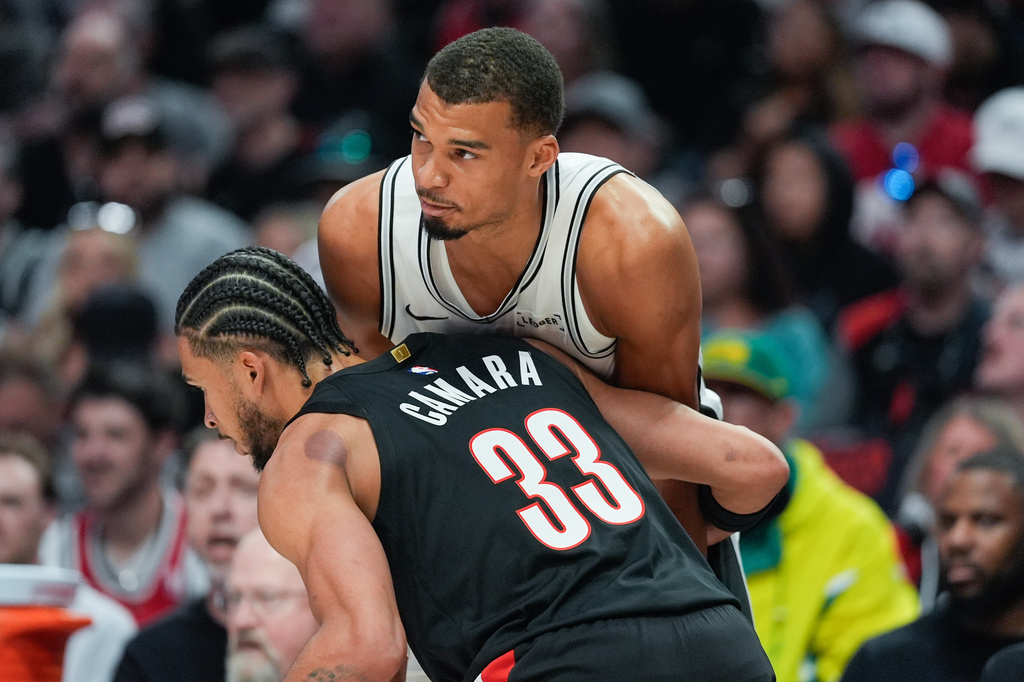 San Antonio Spurs forward/center Victor Wembanyama is guarded by Portland Trail Blazers forward Toumani Camara during the first half in Game 4 of a first-round NBA basketball playoffs series in Portland, Ore., Sunday, April 26, 2026. (AP Photo/Jenny Kane)