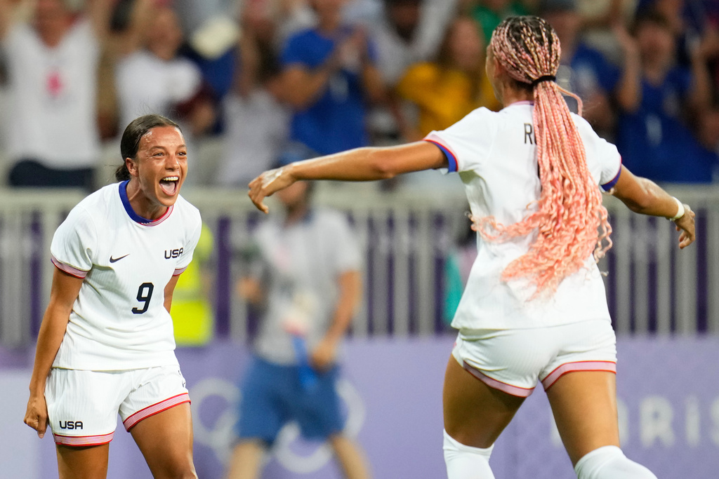 FILE - United States' Mallory Swanson, left, reacts after teammate Trinity Rodman, right, scored a goal during a women's group B match between the United States and Zambia at Nice Stadium at the 2024 Summer Olympics, July 25, 2024, in Nice, France. (AP Photo/Julio Cortez, File)