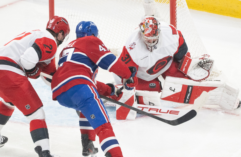 Carolina Hurricanes goaltender Frederik Andersen (31) stops Montreal Canadiens' Jayden Struble (47) as Hurricanes' Alexander Nikishin (21) defends during the second period of Game 3 of the Eastern Conference finals NHL hockey Stanley Cup playoff series in Montreal, Monday, May 25, 2026. (Christinne Muschi/The Canadian Press via AP)
