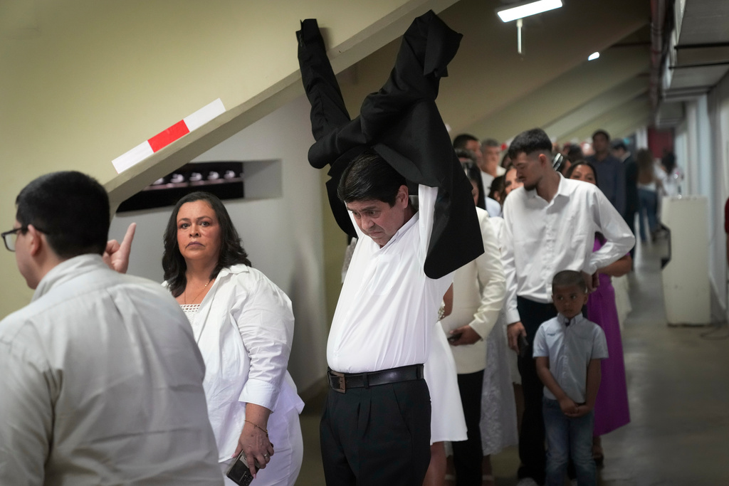 Couples arrive to a stadium to exchange vows during in a group ceremony organized by the Civil Registry to legally formalize their unions in in Asuncion, Paraguay, Saturday, Oct. 4, 2025. (AP Photo/Jorge Saenz)