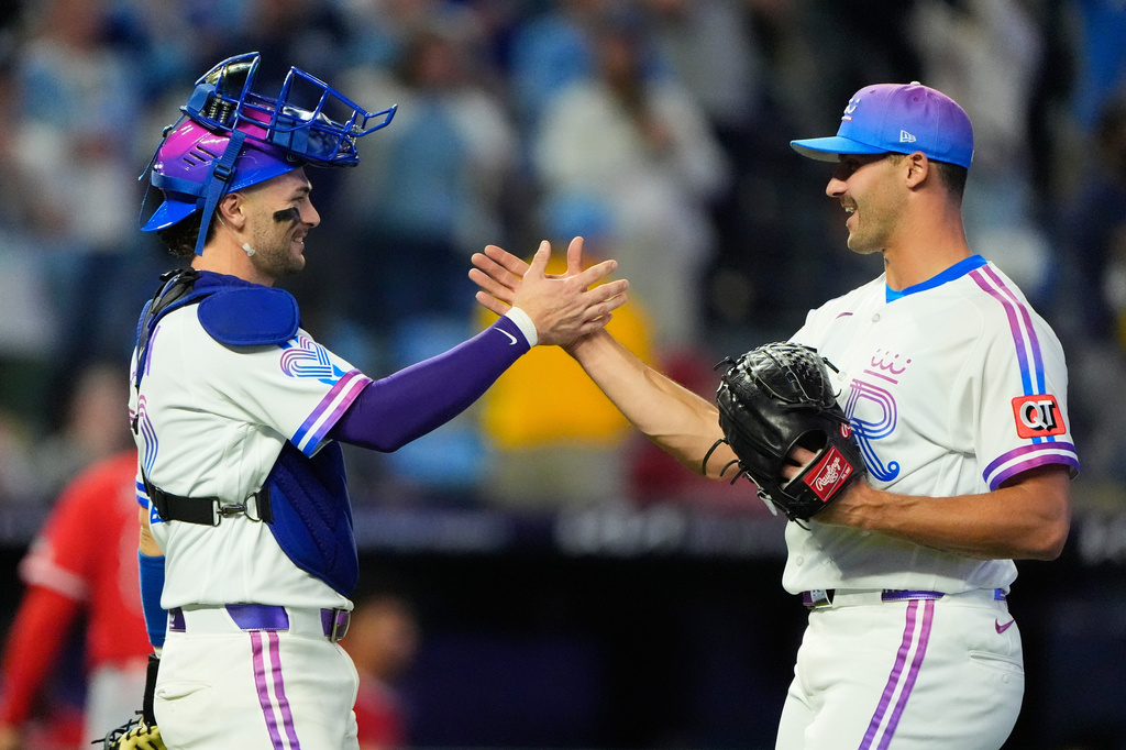 Kansas City Royals catcher Carter Jensen, left, and relief pitcher Mason Black celebrate after their baseball game against the Los Angeles Angels, Saturday, April 25, 2026, in Kansas City, Mo. (AP Photo/Charlie Riedel)