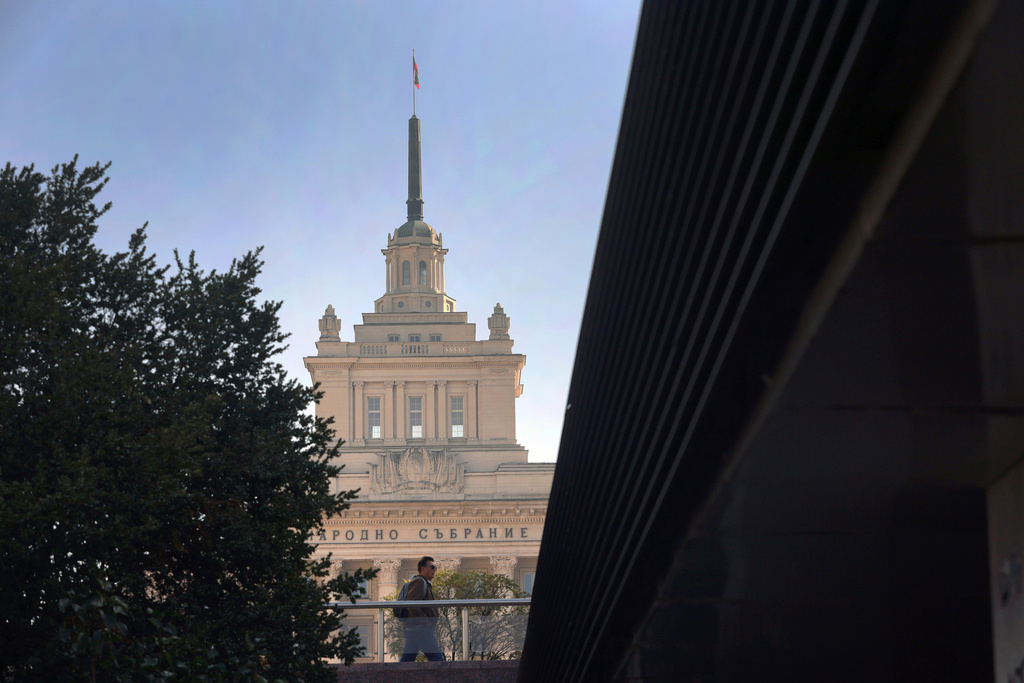 FILE -A man walks backdropped by the Bulgarian Parliament building in Sofia, Oct. 28, 2024. (AP Photo/Valentina Petrova, File)