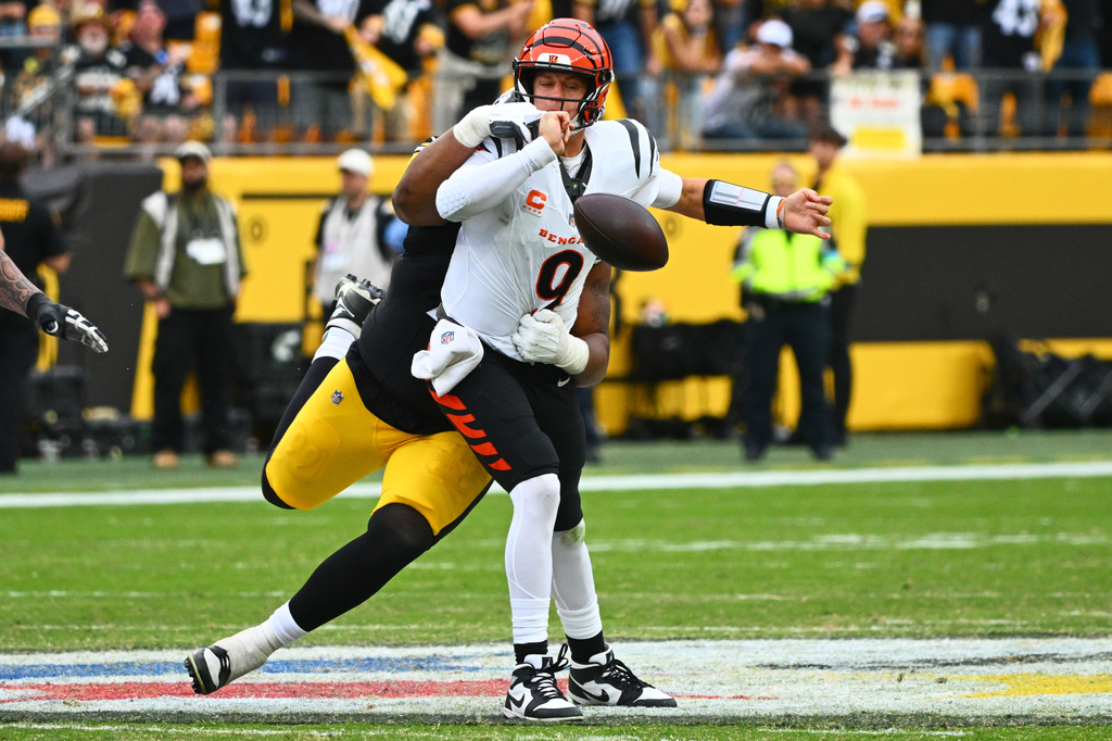 Cincinnati Bengals quarterback Joe Burrow (9) is strip-sacked Pittsburgh Steelers defensive tackle Derrick Harmon (99) by during the second half of an NFL football game in Pittsburgh, Sunday, Sept. 27, 2026. (AP Photo/Justin Berl)